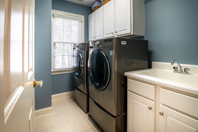 A washer and dryer sitting side by side next to a sink